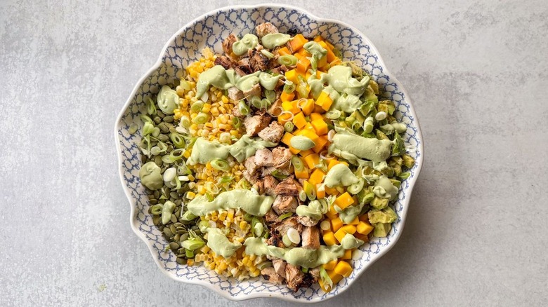 Chopped mango avocado chicken salad with avocado ranch dressing in serving bowl