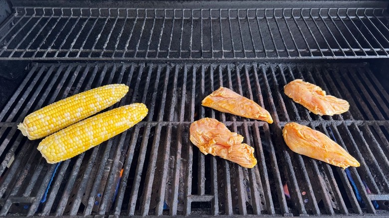 Corn on the cob and chicken breasts on the grill