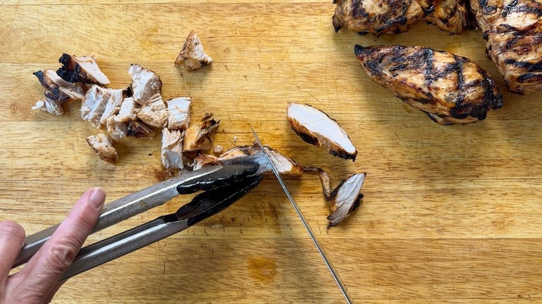 Cutting grilled chicken breasts into cubes