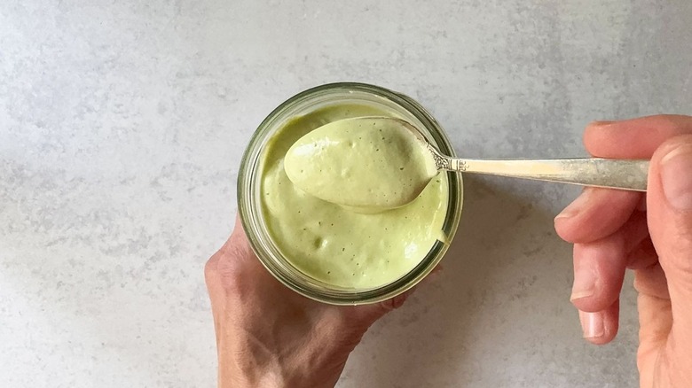 Avocado ranch dressing in jar with spoonful