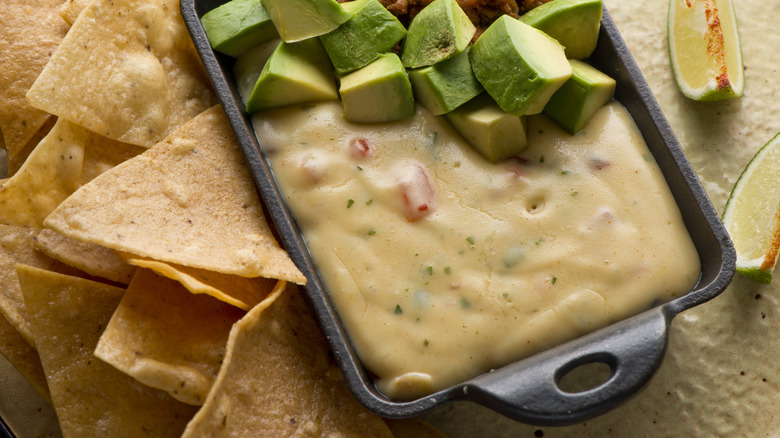 Queso dip melted cheeses mixed with spices and hot sauce. Served with homemade tortilla chips, avocado, and meat
