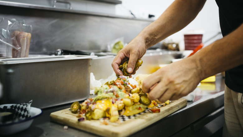 Chef preparing a platter of nachos