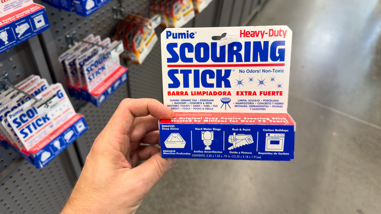 caucasian hand holding a pumie cleaning stick in home goods store