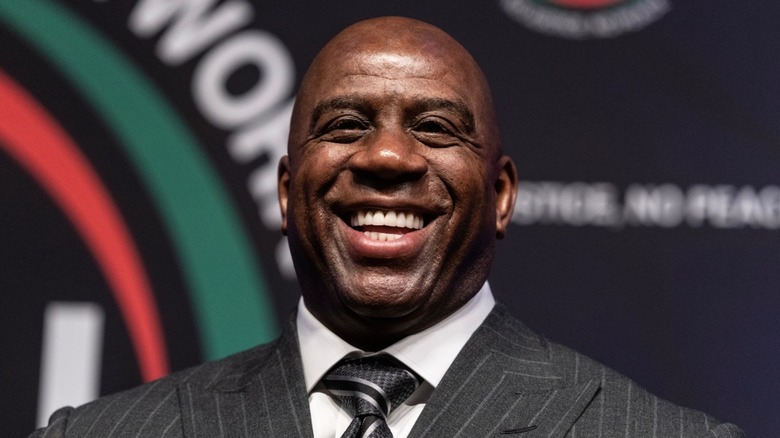 Magic Johnson in a suit smiling