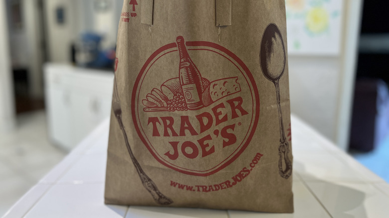 Trader Joe's paper shopping bag sitting upright.