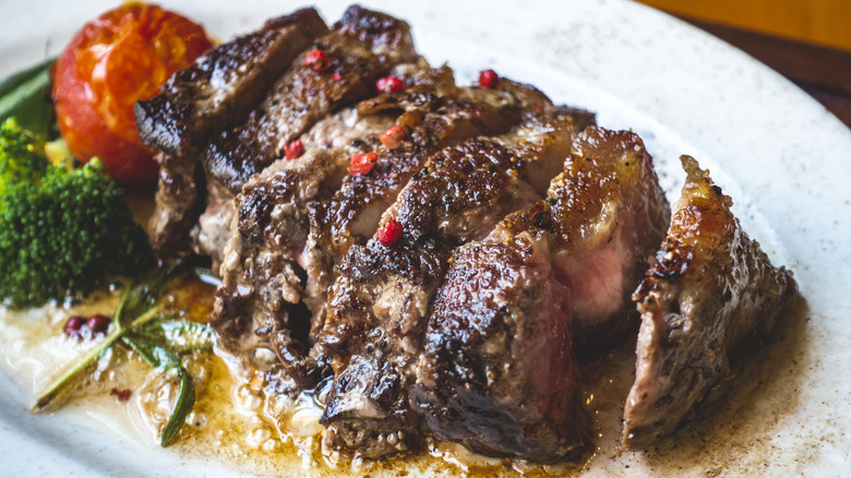 Sliced cooked marinated steak on a cutting board