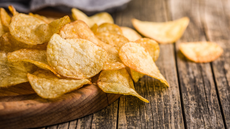 Potato chips strewn on a wooden counter