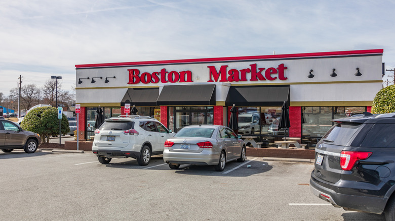 The exterior of Boston Market with a couple of cars parked out front