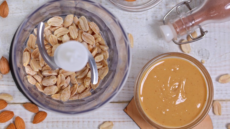homemade peanut butter and fresh peanuts inside a blender