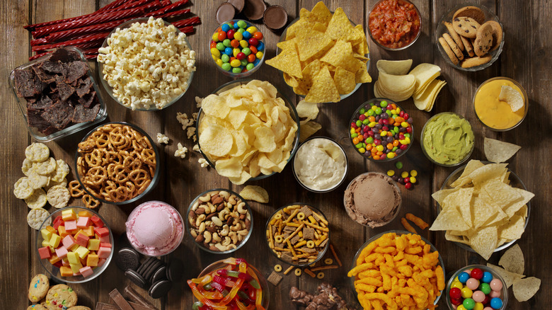 A mix of sweet and salty snack foods on a wooden table