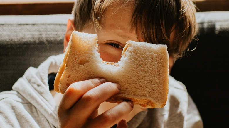 A little boy holding a sandwich