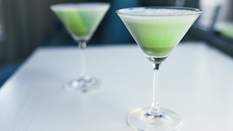 Frozen green blended drinks in martini glasses.