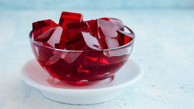 Cubes of shining red Jell-O in a clear glass bowl.