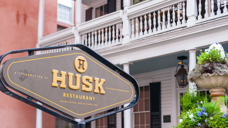 An outdoor sign for Husk, a restaurant showcasing ingredients from the South