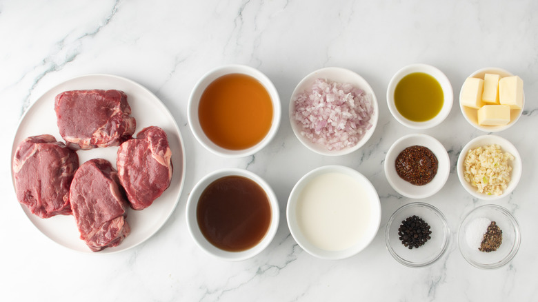 steaks with various bowls of liquids and seasonings