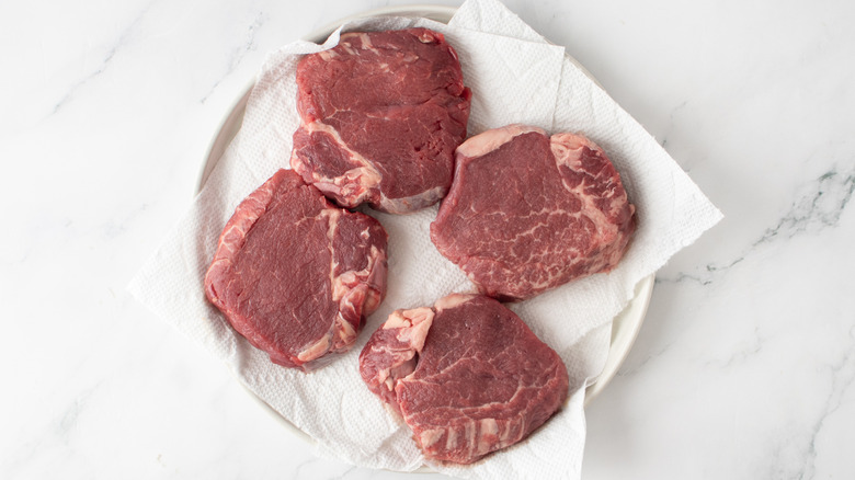 raw steaks on a paper towel