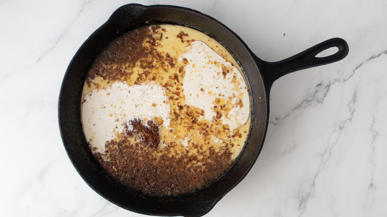 cream and other liquids in a black frying pan