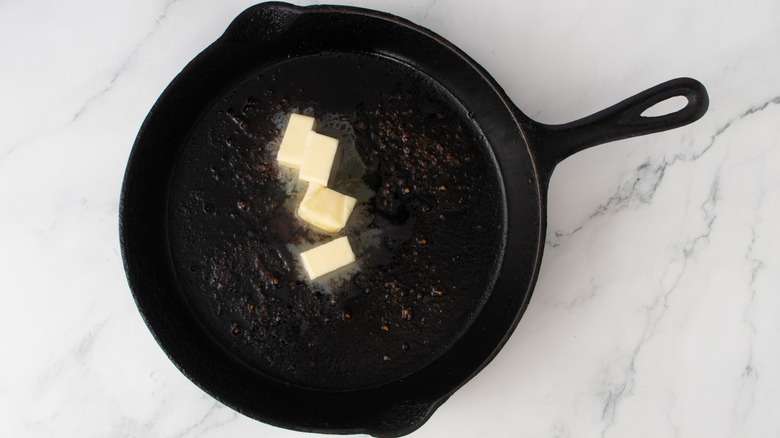 butter chunks in a black frying pan