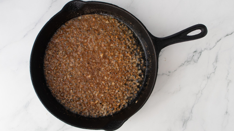 lumpy brown liquid in a black frying pan
