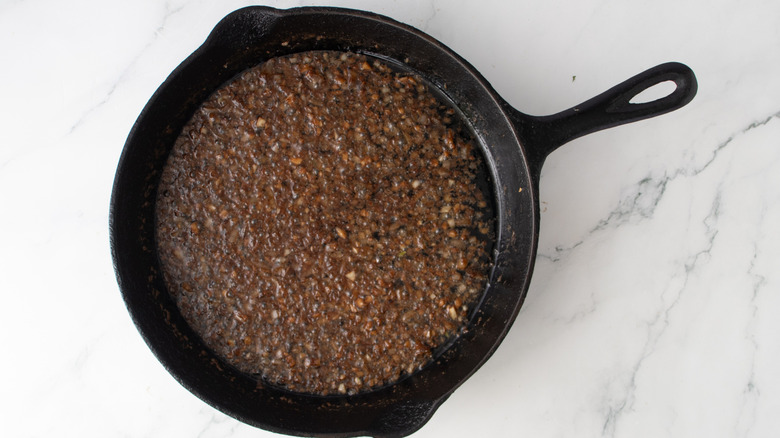 lumpy brown liquid in a black frying pan
