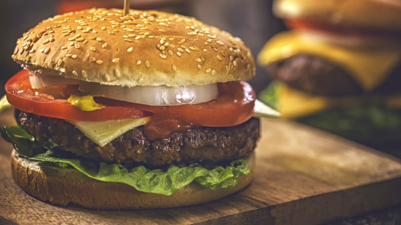 A homemade burger on a cutting board ready to serve