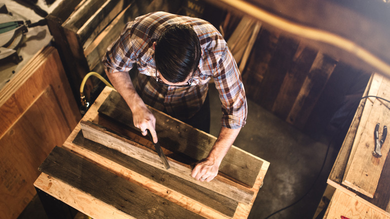 Carpenter working with reclaimed wood in a shop