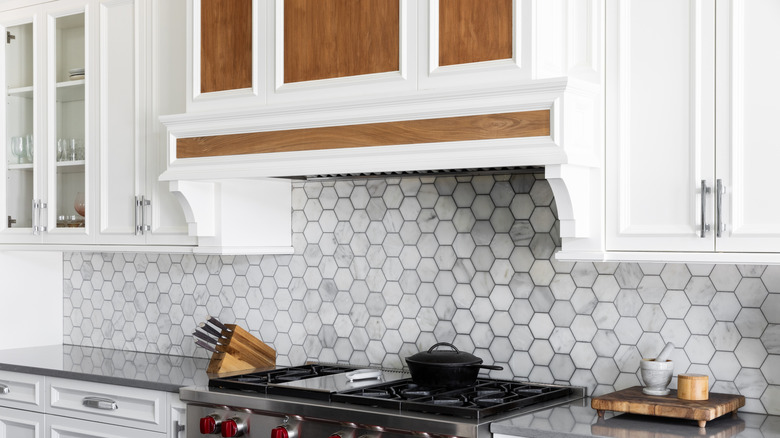 Beautiful wooden range hood above a black stovetop