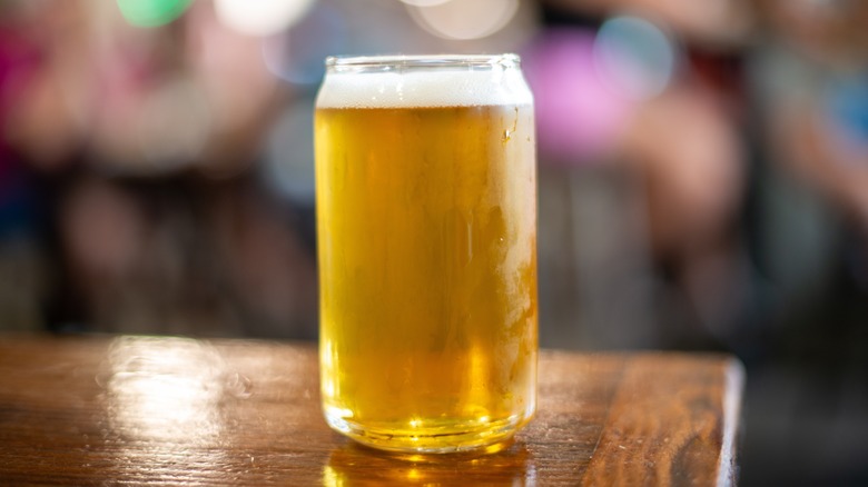 A pint of blonde Belgian ale sitting on a wooden table