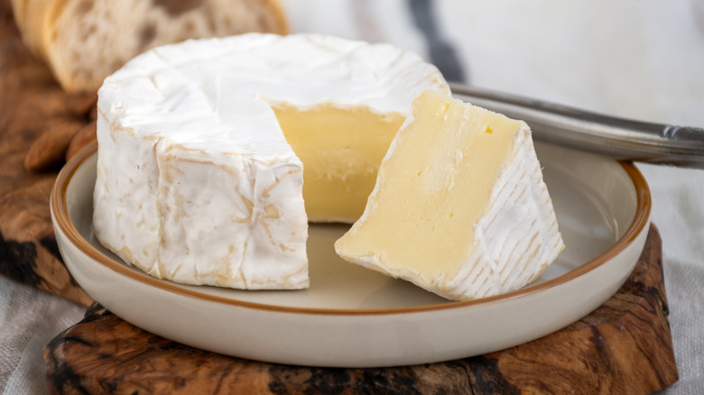 wheel of soft creamy brie cheese on a plate