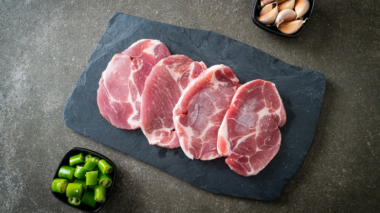 Pork chops are photographed from above on a cutting board.
