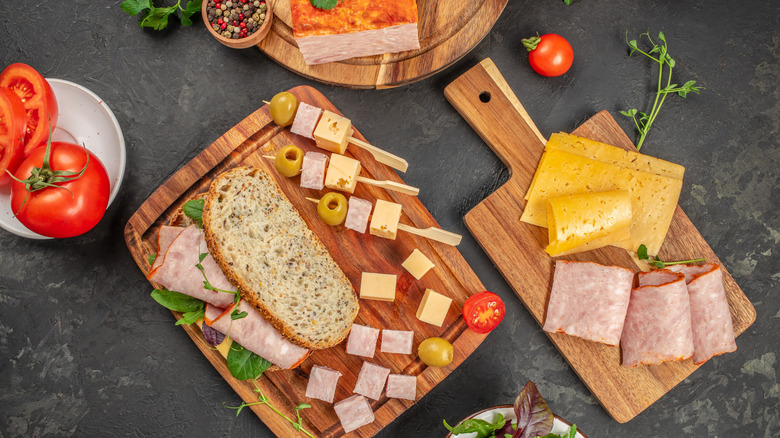 Sandwich spread of ham, cheese, olives, salad greens, and multigrain bread