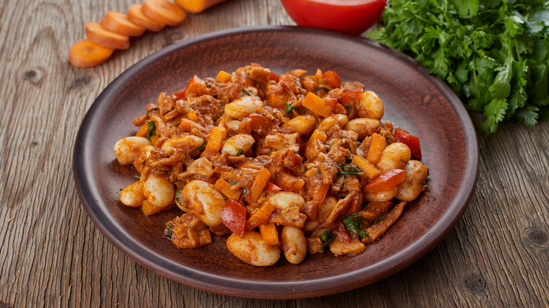 A bowl of bean stew on a table.