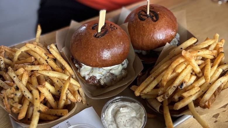 Two truffle burgers and orders of truffle fries with sauce from Burgers & Half Bottles