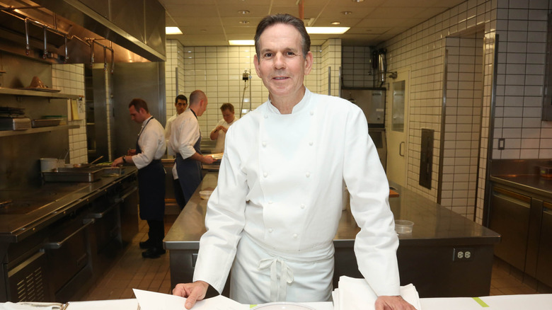 Thomas Keller in a kitchen with cooks behind him