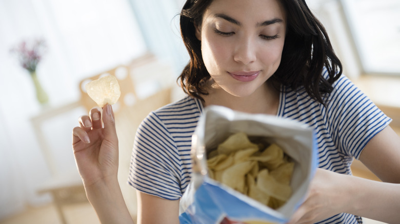 Woman inspecting label on chip bag