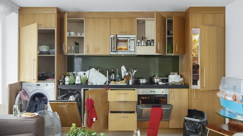 Messy kitchen with open cabinets