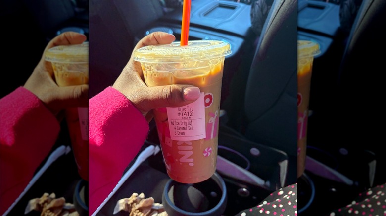 Person holding a Dunkin' iced coffee