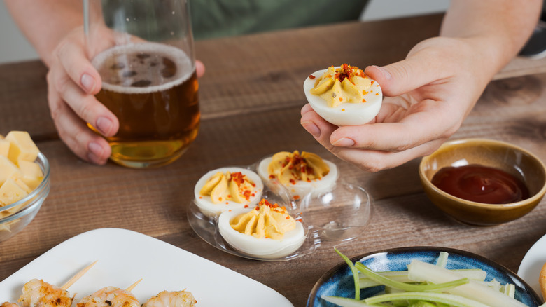 Hand holding deviled eggs