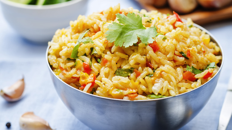 Bowl of seasoned rice with vegetables and herbs