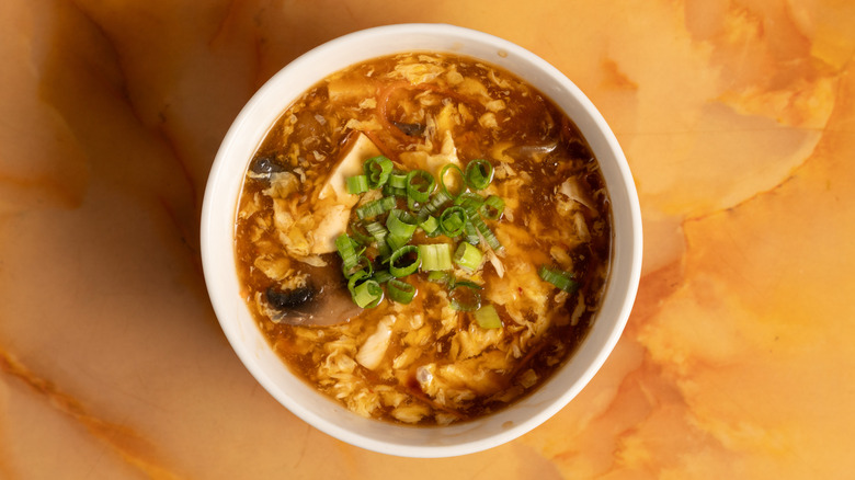 Hot and sour soup in a white bowl.