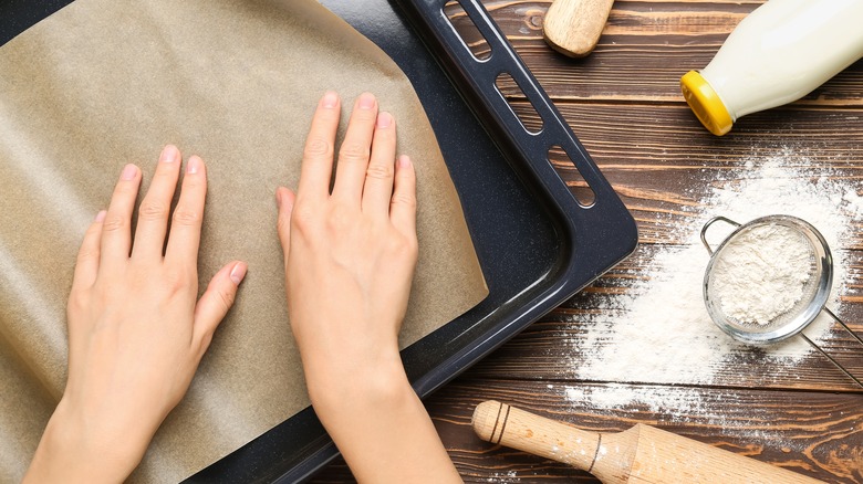 Women lining tray with parchment
