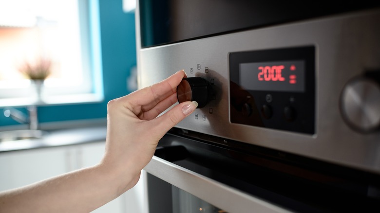 Woman setting oven temperature