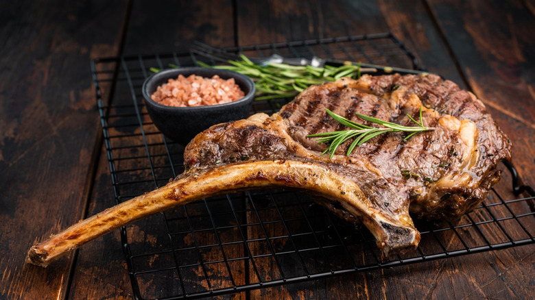 Raw tomahawk steak on a black blackground
