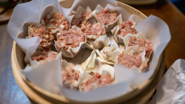 Raw filling in shumai dumplings, in a steamer basket.