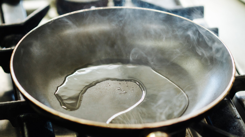 Hot oil steams in a heated pan.