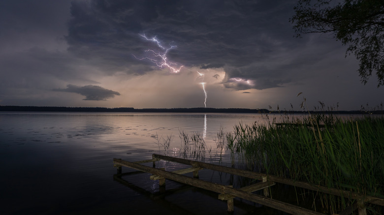 Lightning across a body of water with pier in the foreground
