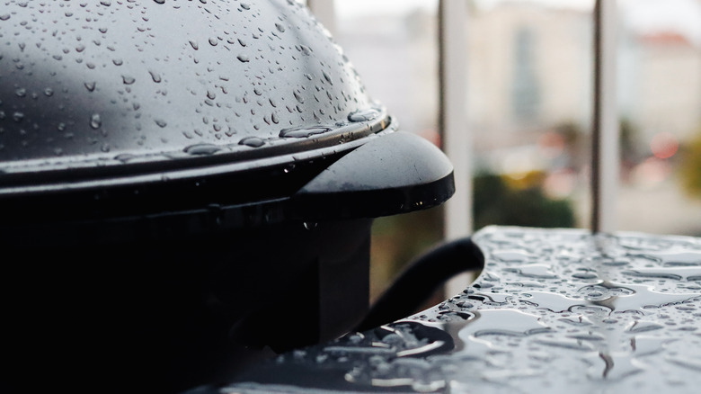 A black charcoal grill is covered in water