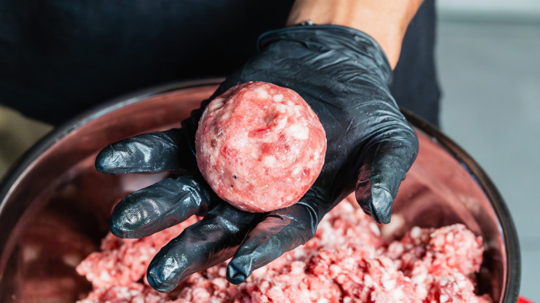 A chef forming ground beef in ball