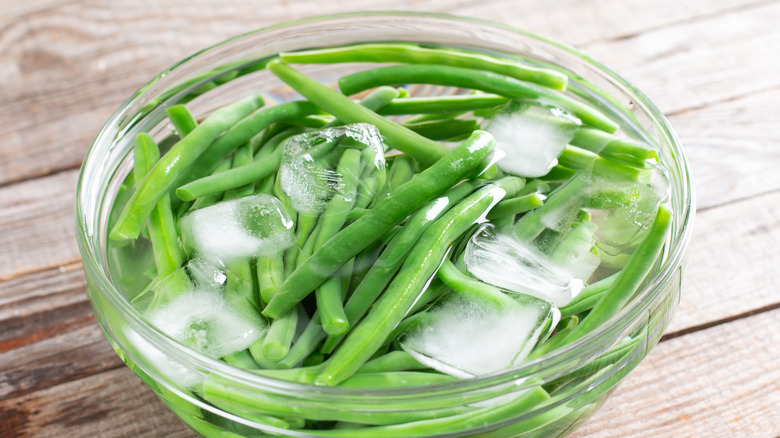 Blanched green beans in an ice water bath