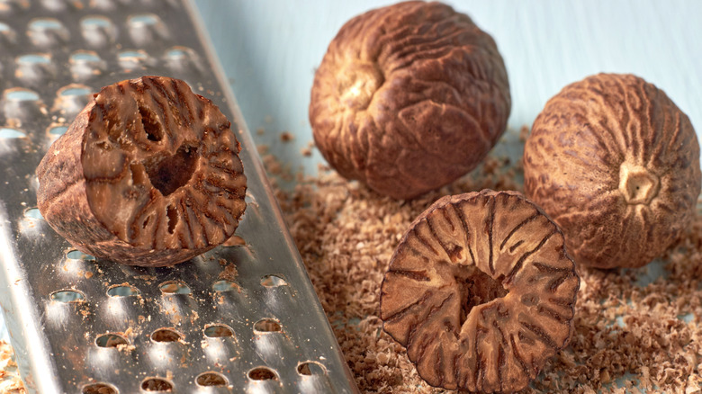 Whole and grated nutmeg with a metal grater
